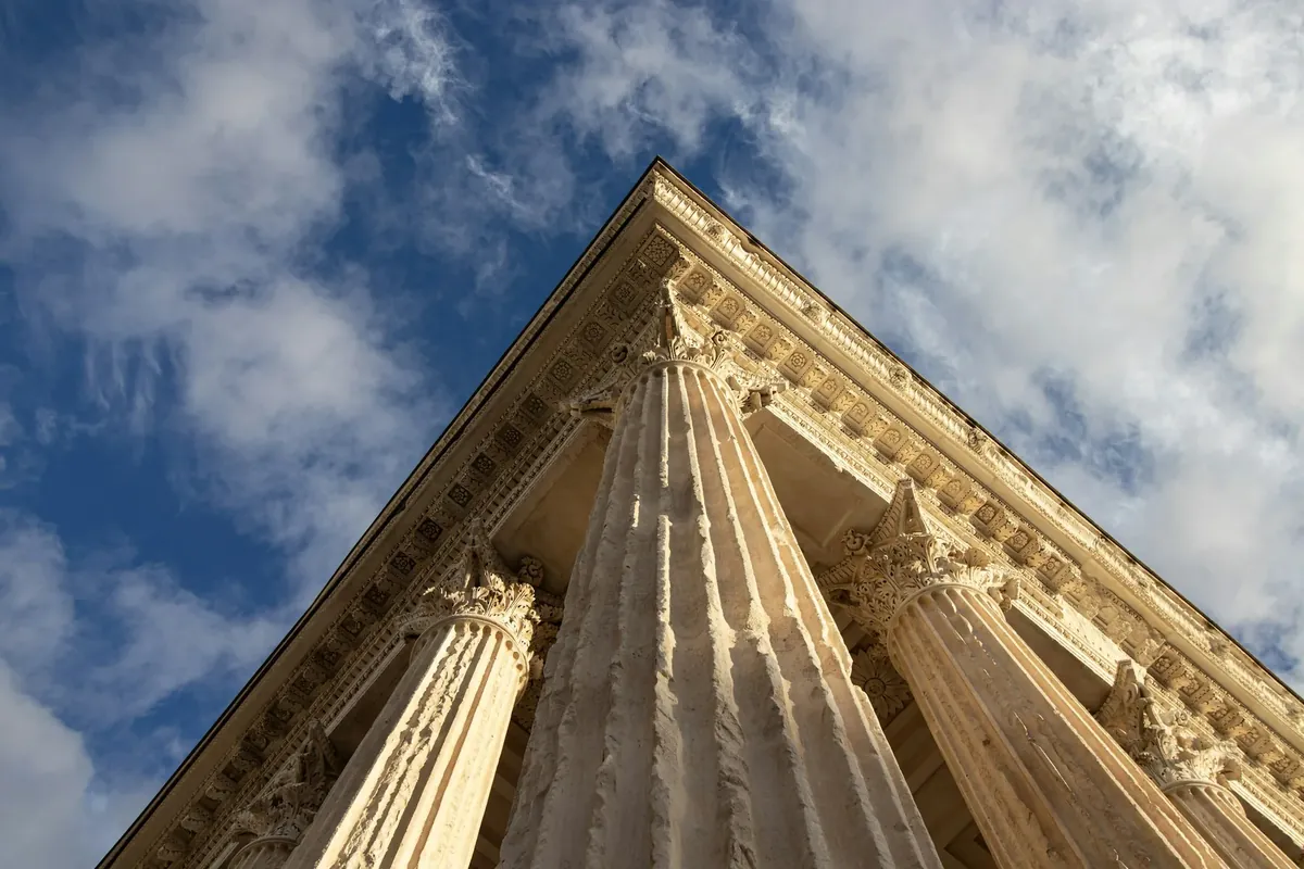 Les colonnes de la Maison Carrée, à Nîmes, sur fond de ciel